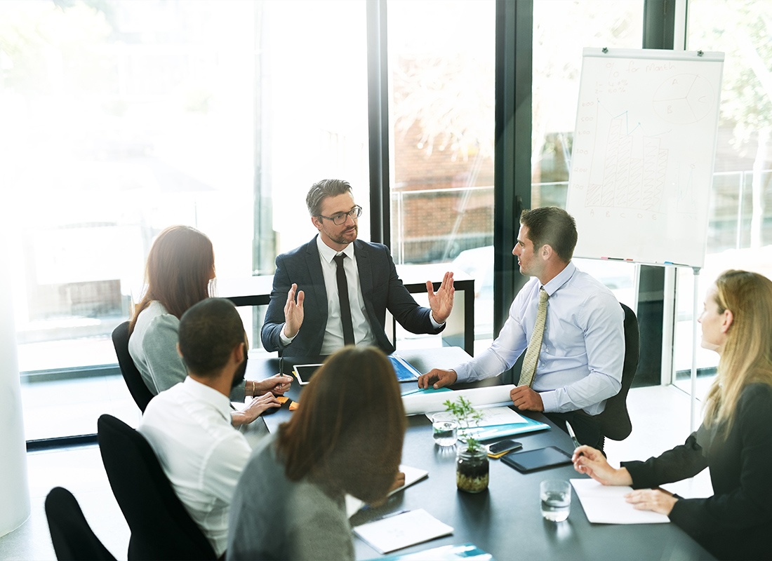 Business Insurance - A Team of Executives Having a Formal Meeting in a Boardroom Working Through the Meeting Agenda Like Pros