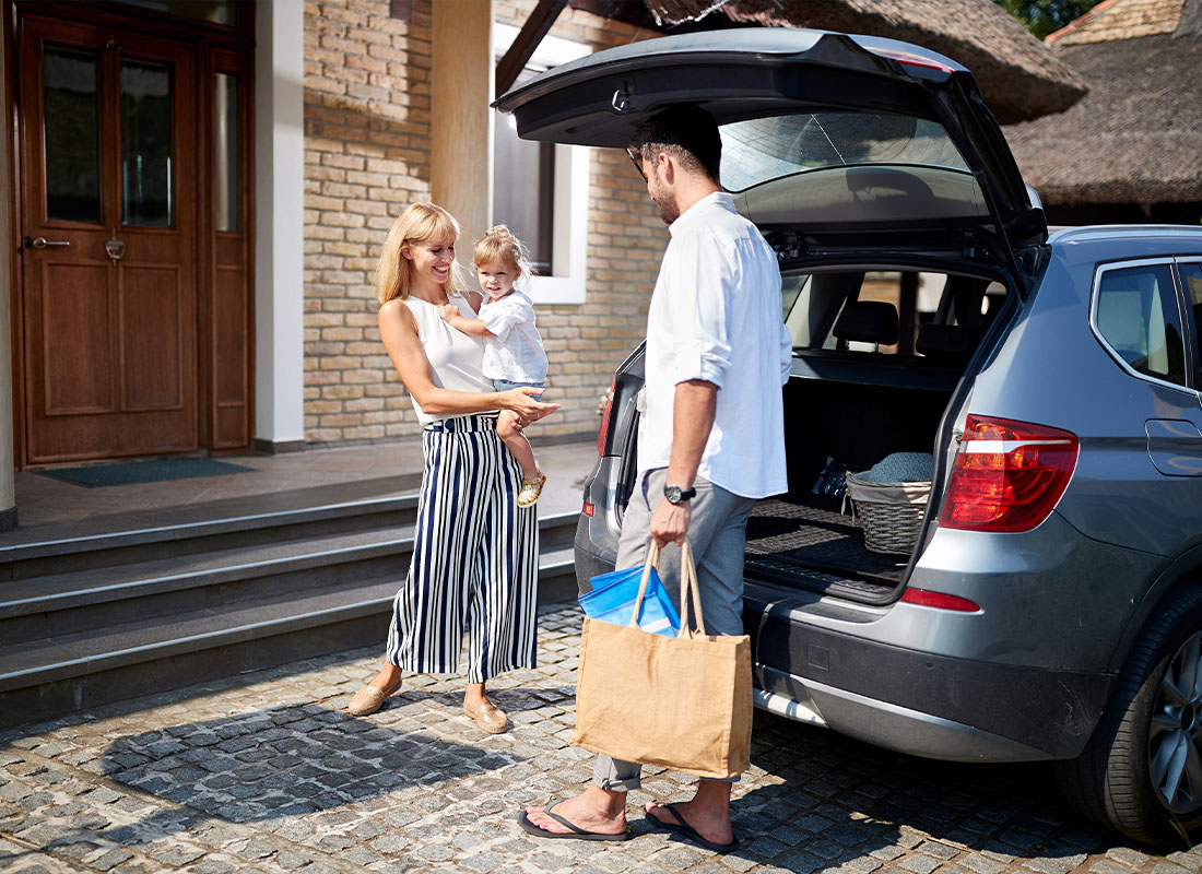 Personal Insurance - Happy Family Returning Home After a Trip With Bags in Their Hand While Standing by Their Car